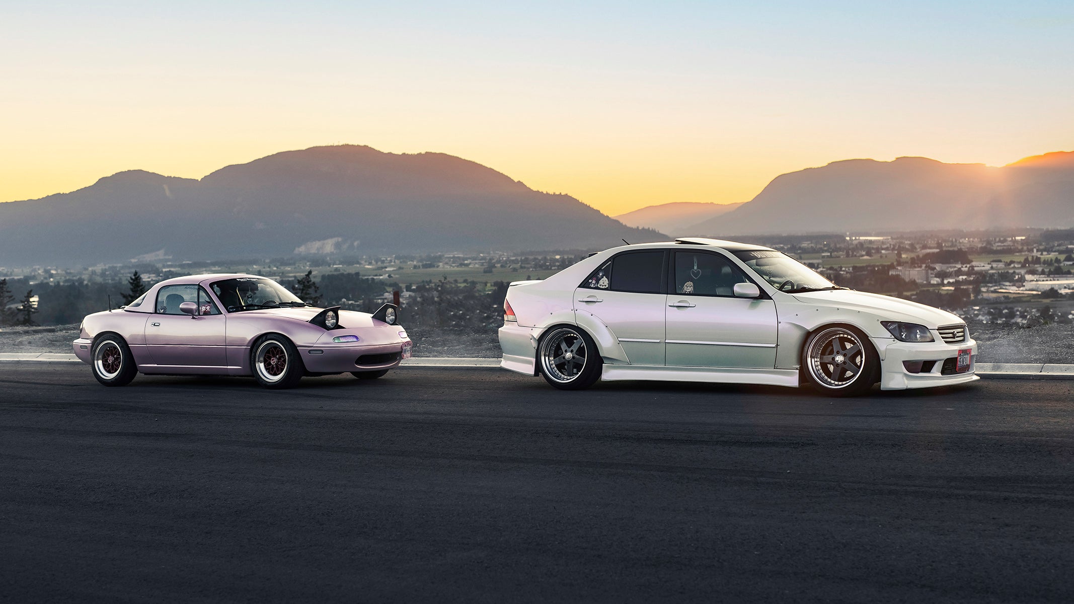 pink miata and widebody lexus is300 on beautiful mountain backdrop