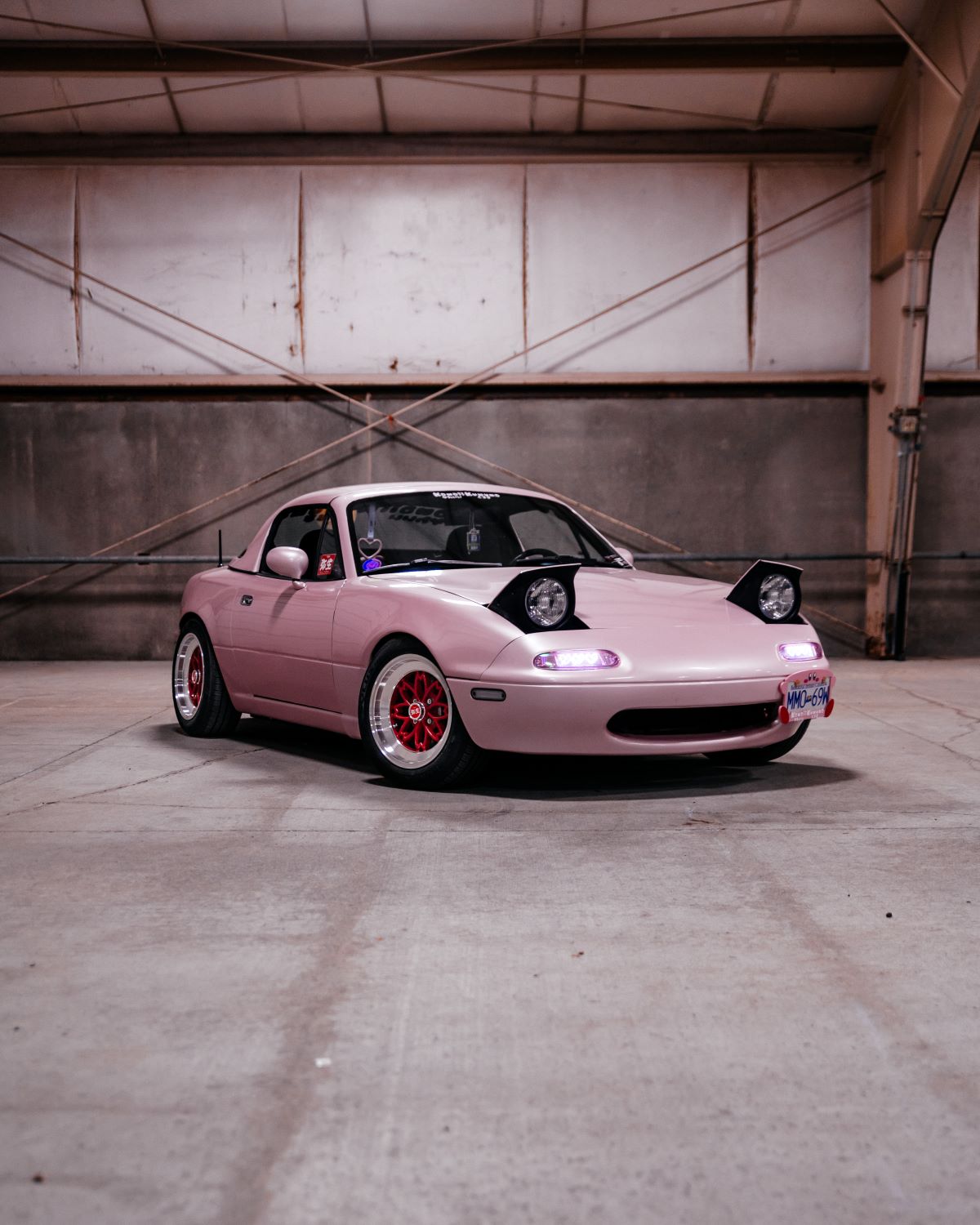 pink mx5 mazda miata in a colorful alleyway in vancouver on hayashi yayoi wheels with heart shaped lights. Famous car from tiktok